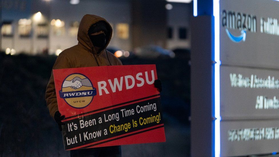 man with RWDSU sign outside warehouse in Alabama